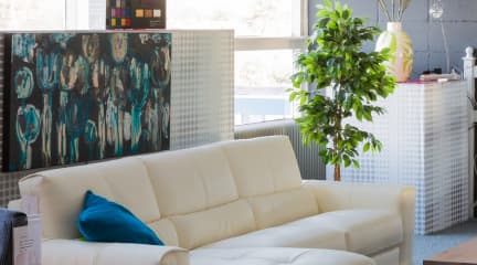White couch with a blue pillow in a modern workspace