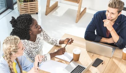 Three colleagues smiling during office meeting