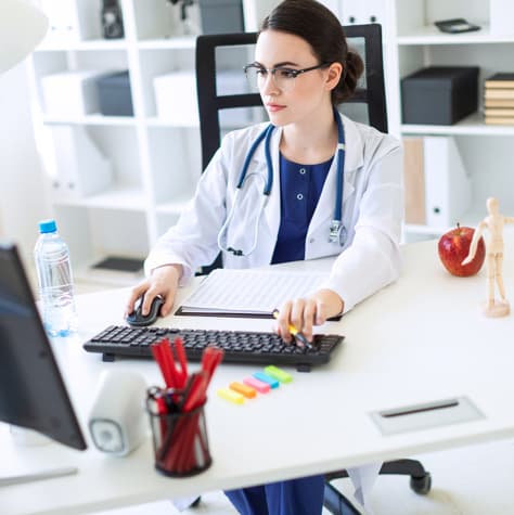 Female healthcare professional working on a desktop computer