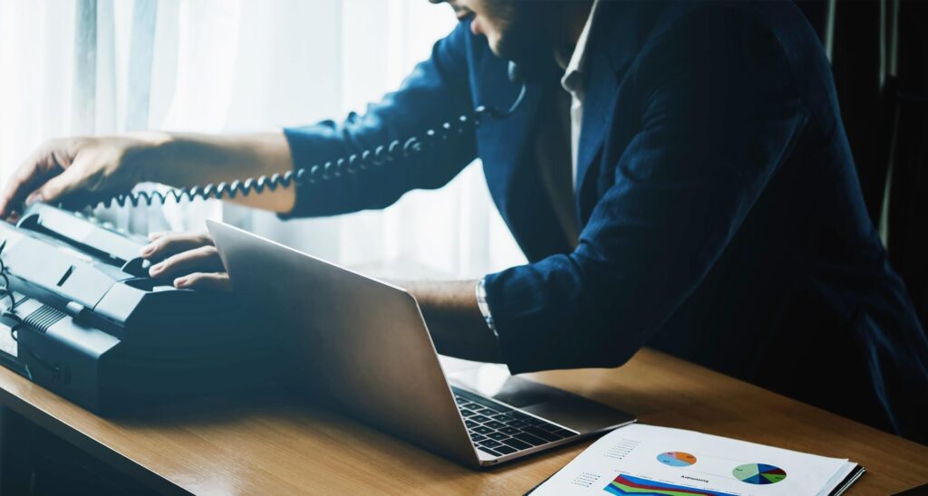 Male professional talking on the phone while using printer