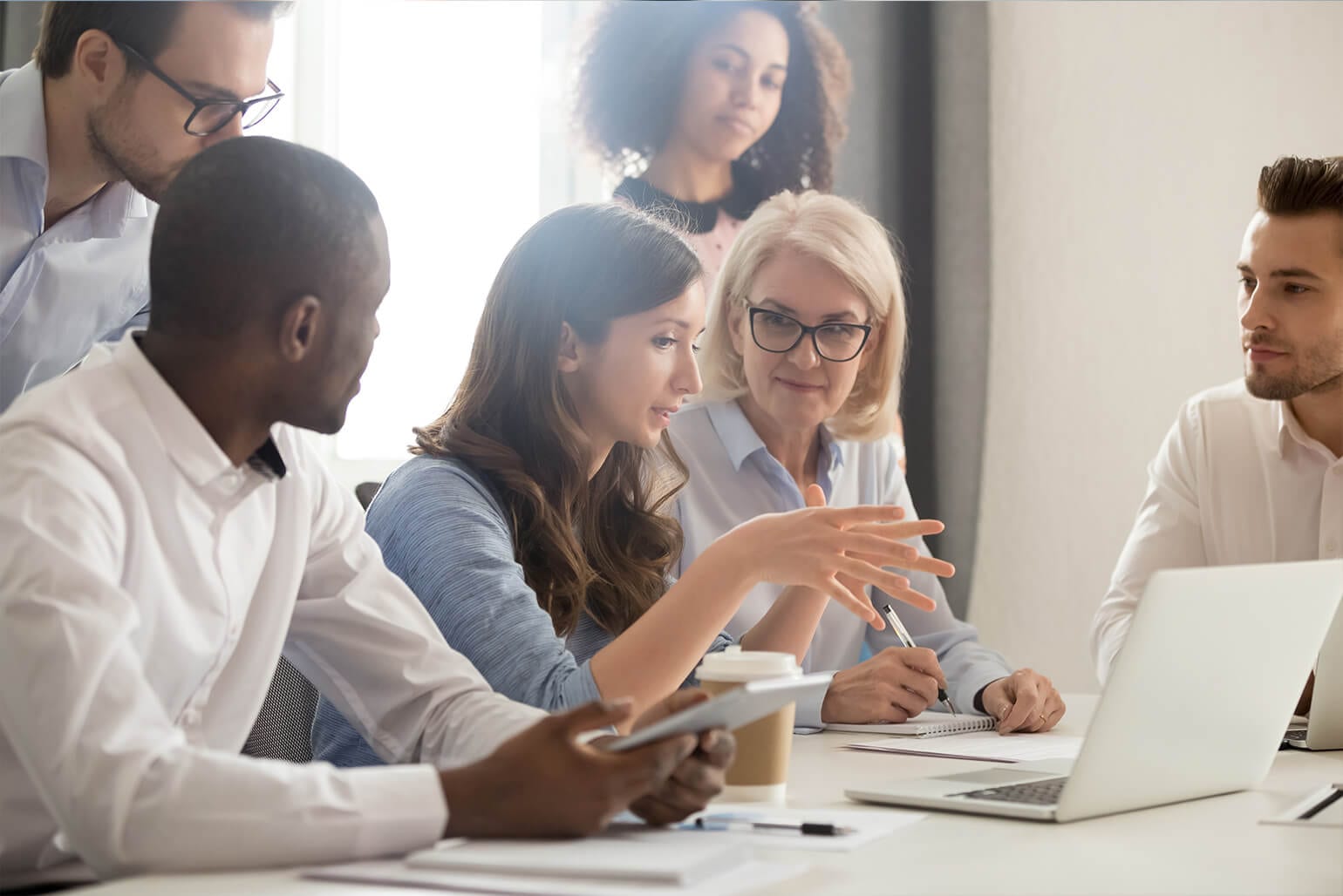 A female employee discusses her ideas while her co-workers listen