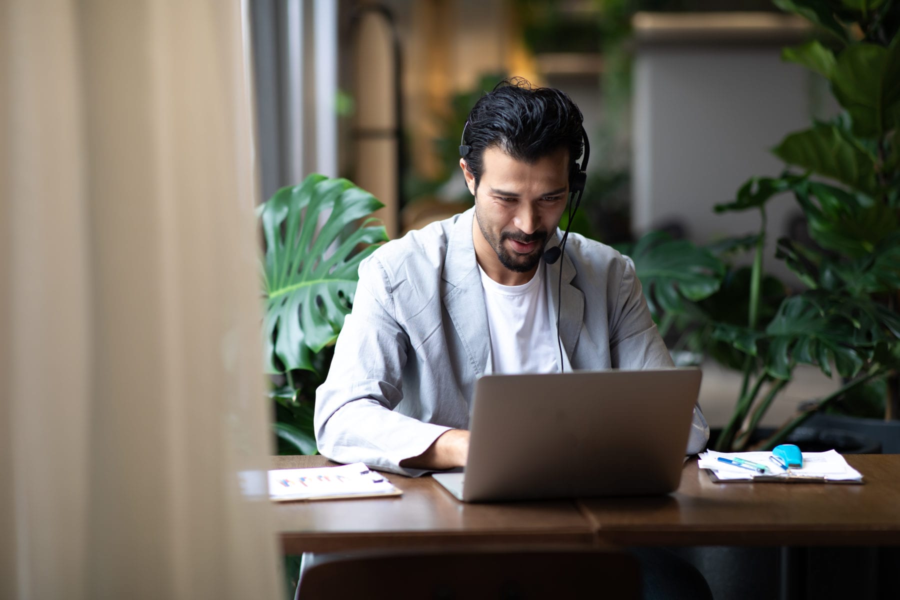 Attractive business man in suits and headsets smiling while work