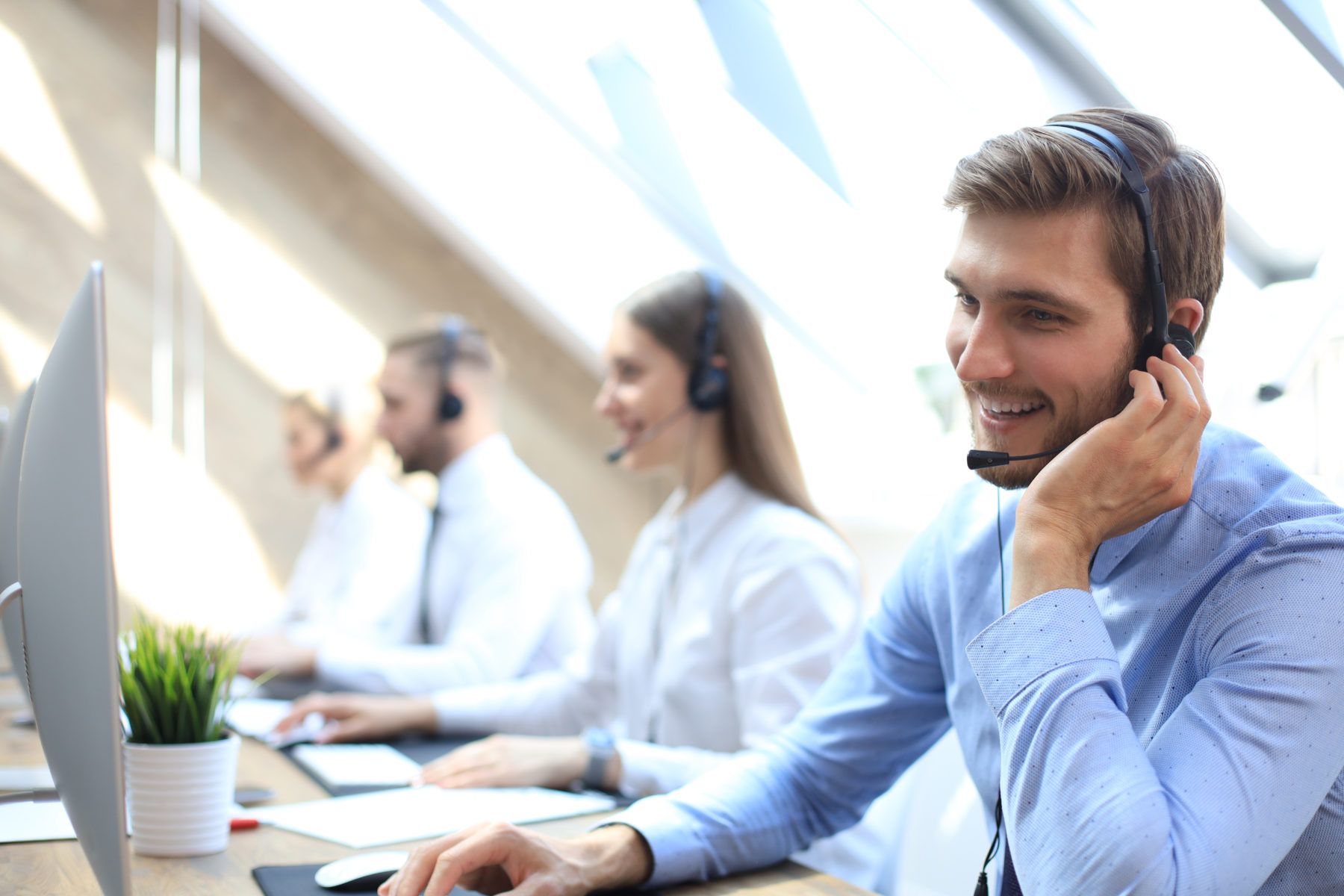 portrait call center worker accompanied by his team smiling customer support operator work scaled