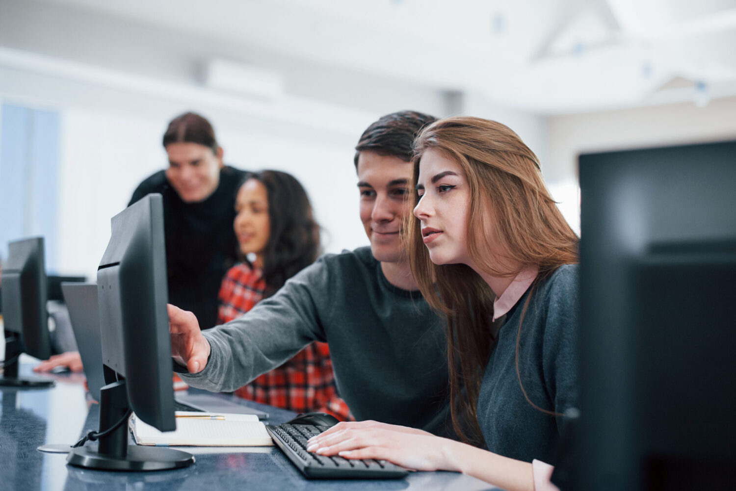 Giving advice. Group of young people in casual clothes working in the modern office