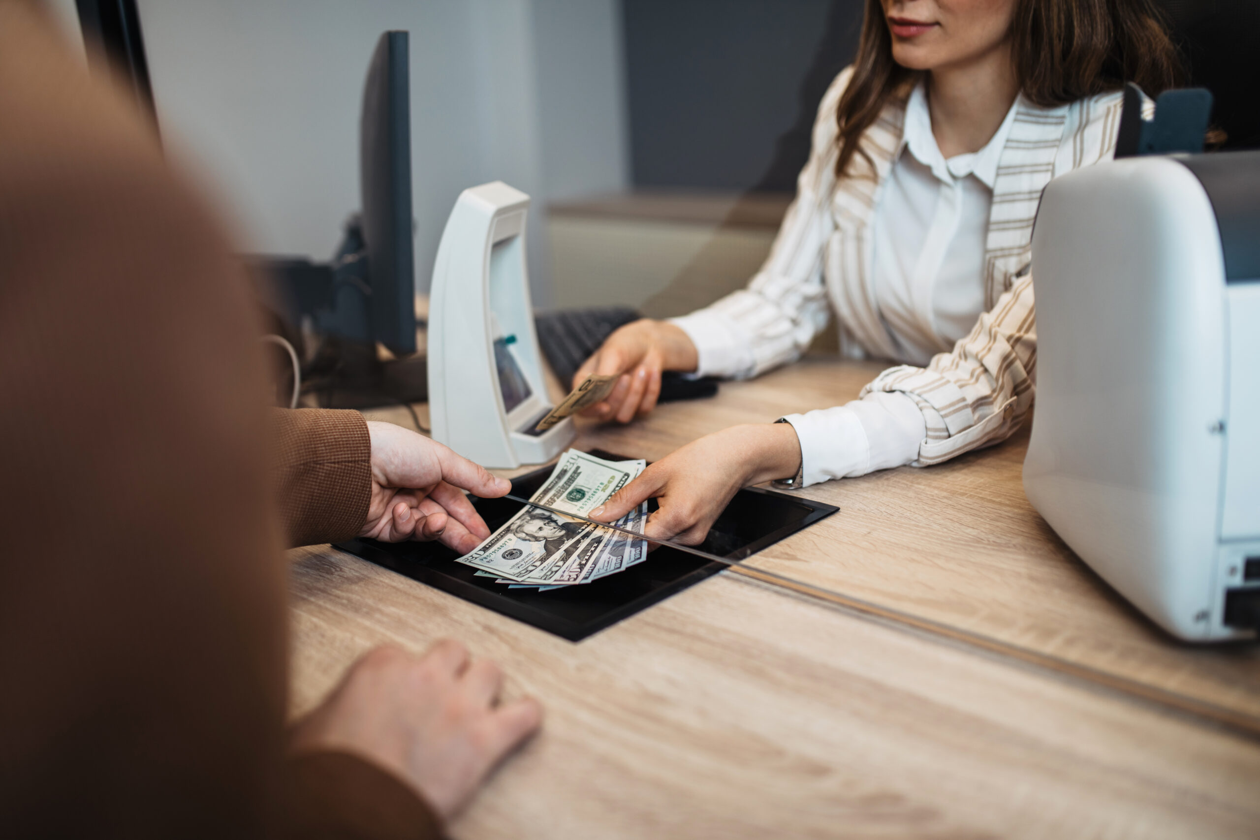 Businesswoman-is-working-in-exchange-office-giving-cash-money-to-customer